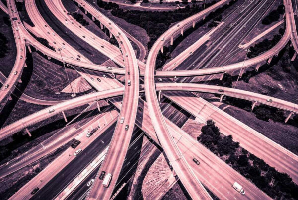 Aerial view of a complex multi-level freeway interchange with many looping ramps and cars.